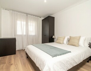 Modern bedroom with wooden floors, white bedding, and dark furniture