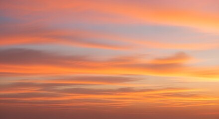 Fototapeta premium Vibrant orange-pink sky over soft clouds at dusk
