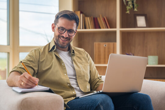 Young home-based online therapist in virtual counseling session, focused mental health professional listening to client on video call taking notes offering support and empathy in calm domestic setting