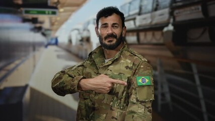 Man in military uniform with brazilian flag patch on shoulder stands on cruise ship deck pointing at flag confidently under bright lighting. - Powered by Adobe