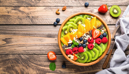 Vibrant smoothie bowl on wooden table with colorful fruits and nuts artfully arranged in bright natural light setting