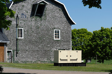 An industrial generator near a farm building