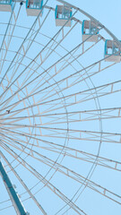 Obraz premium Close view of Ferris wheel cabins on sunny sky background in park setting