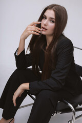 beautiful woman with dark long hair in elegant masculine style suit and tie