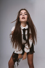 beautiful woman with dark long hair in elegant clothes, white fashion blouse and black skirt posing...