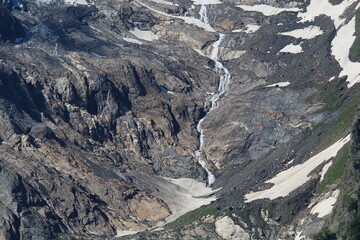 melting glaciers flowing into small rivers in the North Caucasus mountains in Dombai in midsummer