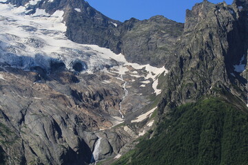 melting glaciers flowing into small rivers in the North Caucasus mountains in Dombai in midsummer