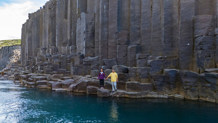 Visitors marvel at the breathtaking basalt columns and turquoise waters of Studlagil Canyon in...