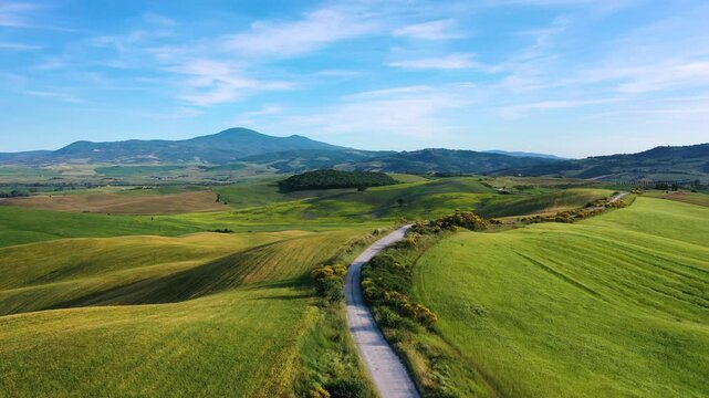 Aerial View of Off Road Trail Winding Through the Rolling Hills of Tuscany in Spring