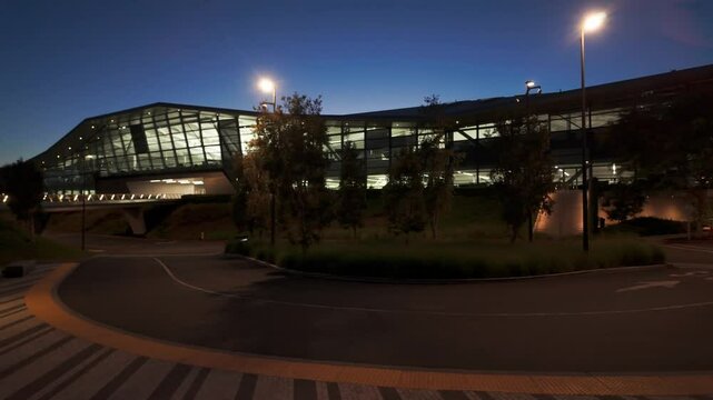 Gimbal wide panning shot of a shuttle stop at the Endeavor Building on the Nvidia campus at twilight in Silicon Valley, California. 4K
