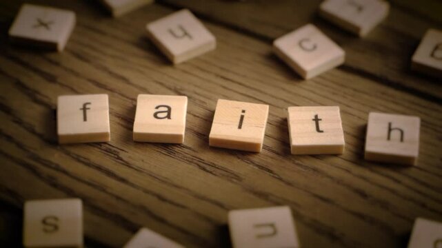 Wooden tiles spell the word faith as the camera pans across a rustic wood surface with soft cinematic lighting.