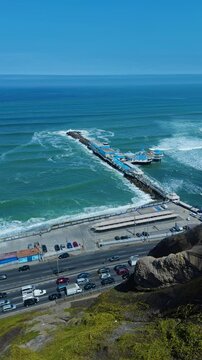 High angle vertical establishing of La Rosa Nautica in Lima Peru beach, ocean road below clifs