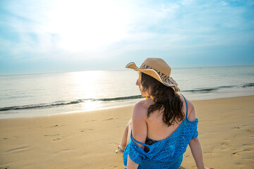 Rear view of young model observing horizon with hat on beach at Patong beach