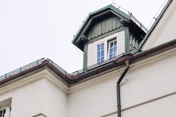 Windows with muntins reflecting blue sky on bright building facade, architectural detail showing symmetry, light, and classic window design elements