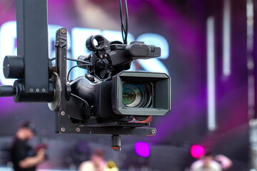 Professional video camera on a crane during an outdoor event.