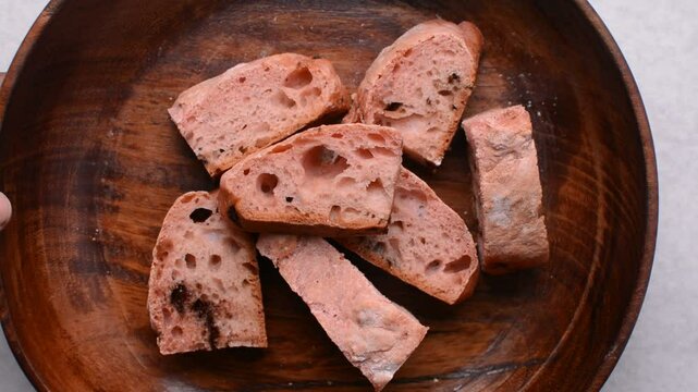 Overhead view of strawberry and chocolate sourdough on a wooden plate, top view of pink and chocolate artisan bread in a wooden bowl, pink open crumb artisan bread