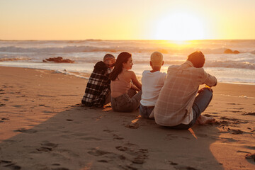 Friends enjoying golden sunset on sandy beach