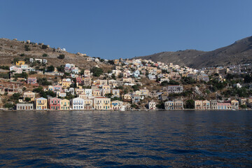 Fototapeta premium Case colorate sulla costa dell’isola con mare calmo e cielo azzurro..