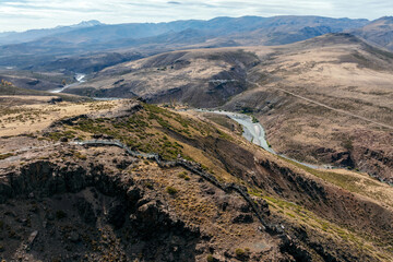 Aerial view of La Puntilla lookout platform overlooking a valley with Neuquen river and distant mountains. Neuquen, Argentina