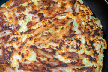 調理中のお好み焼きの写真。