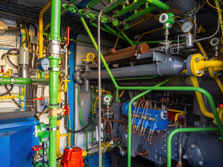 Complex industrial piping system with pressure gauges, valves, compressors, and control units for...