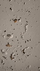 Close-up of a textured white wall with small dents and chips