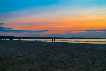 Fototapeta premium Swinemünde -Polen. Ein Strand bei Sonnenuntergang und Farben Reflektionen im Meer