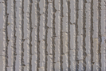 Vertical bricks with broken edges form a vertical impregnable wall. Abstract architectural...