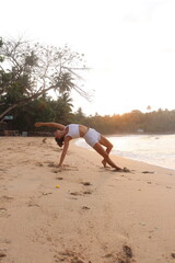 woman yoga in the sunrise with the beach
