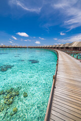 Stunning Maldives water villas wooden pier over turquoise sea bay picturesque summer landscape. Amazing luxury travel tropical beach vacations. Honeymoon tourism destination paradise, sunny blue sky