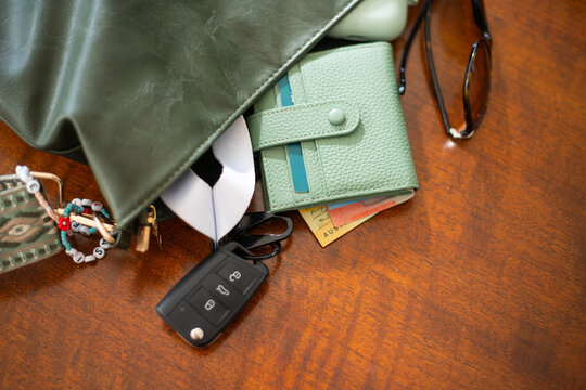 a bag with a wallet with cash, sunglasses and keys