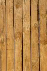 Rough-cut wooden boards. Barrier fence made of unplaned boards.