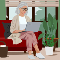 senior woman sitting on a sofa with laptop