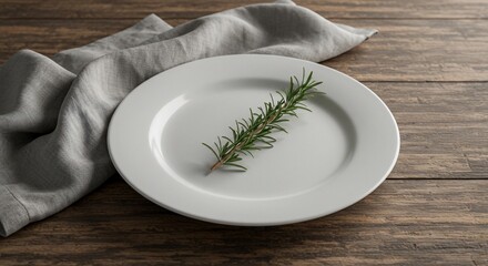 Simple rosemary sprig on white plate with linen cloth on rustic wood table