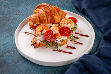 Delicious croissant sandwich filled with grilled shrimp, fresh arugula, cherry tomatoes and cream...