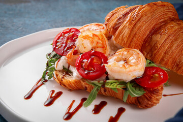 Delicious croissant sandwich filled with grilled shrimp, fresh arugula, cherry tomatoes and cream...