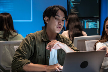 Young Asian business people working late into the night in the office, meeting, brainstorming,...