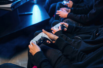 Holding controllers. Close up view of hands of gamers that playing game on console