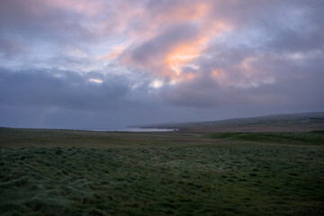 Grassy landscape with mounds of the cliffs of Downpatrick Head with the Atlantic Ocean Co. Mayo,...