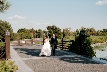 bride and groom walking in the park
