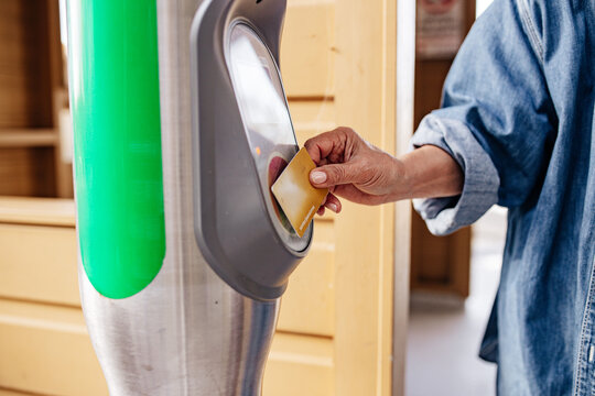 Senior Asian woman scanning her concession card tapping on