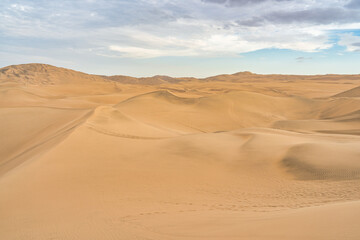 Ica desert landscape with smooth golden sand dunes near Huacachina, Peru.
