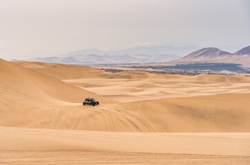 Buggy car on the sand dunes in the desert of Ica in Huacachina, Peru.