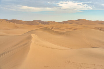 Ica desert landscape with smooth golden sand dunes near Huacachina, Peru.
