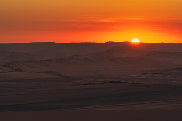 Golden sunset over the vast dunes of the Ica Desert near Huacachina, Peru.