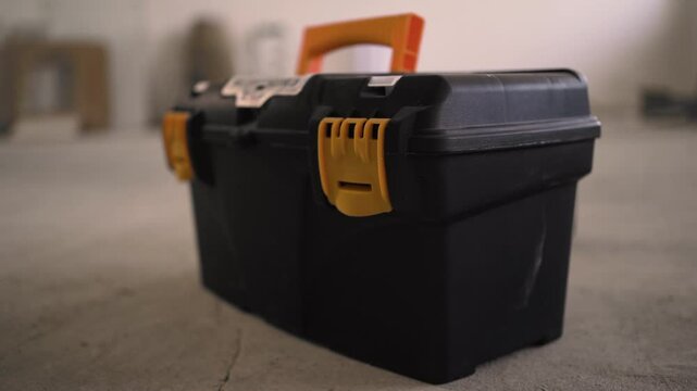 Close up female hands unlocking toolbox. Woman worker holding plastic box. Repairman with tools box.