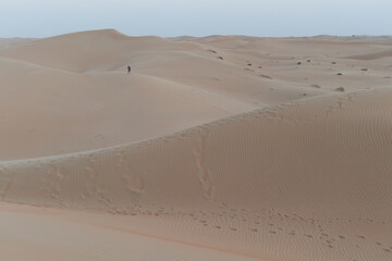 Uomo solo tra le dune del deserto al crepuscolo