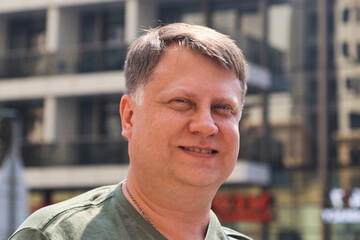 Portrait of a 45 Year Old Man with Light Hair Against Urban Building Background.