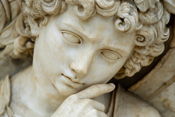 Naklejka premium Close-up of marble angel statue with curly hair