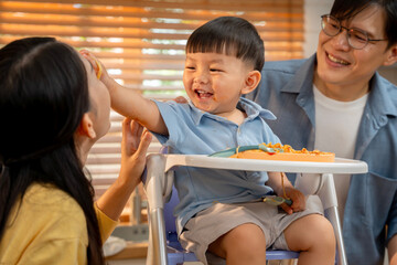 Happy family moment. A smiling boy enjoys mealtime with parents.